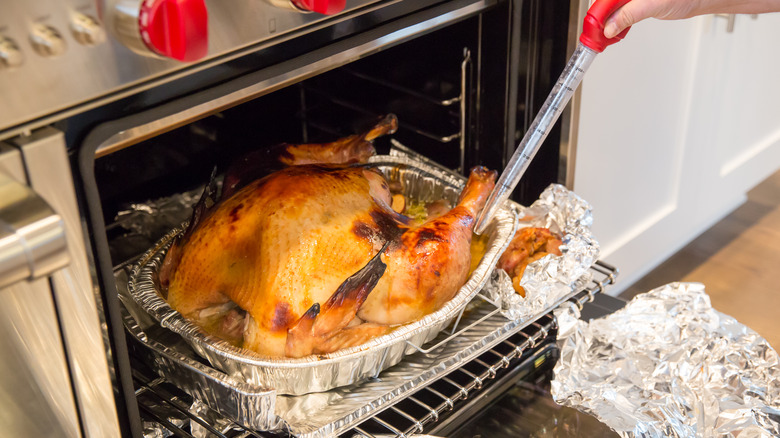 Basting a turkey while it's roasting in the oven