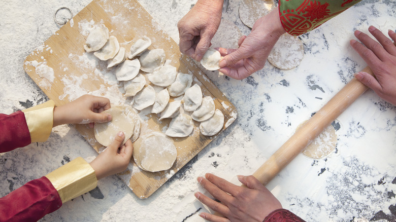 people wrapping dumplings