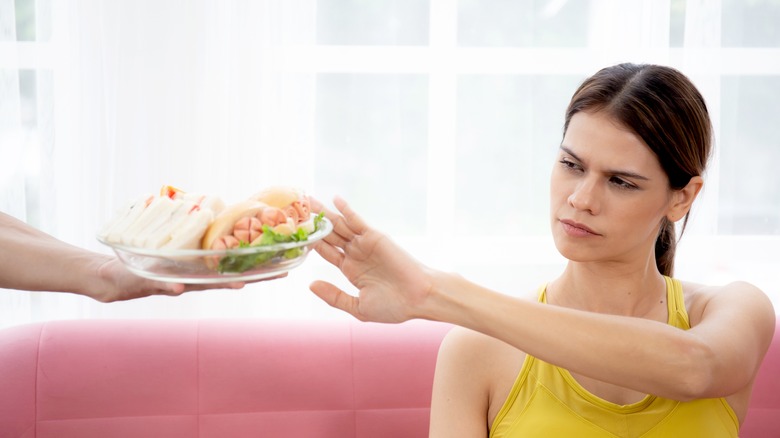 Woman saying no to plate of food