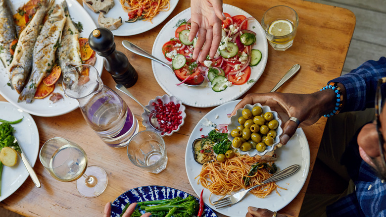 People dining around table with several shared plates