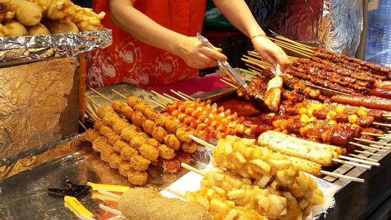 Street food stall with various skewered foods