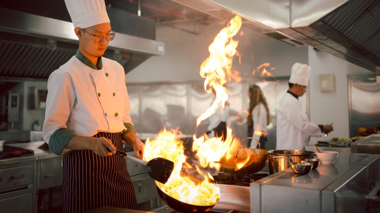 Chef cooking with fiery pan