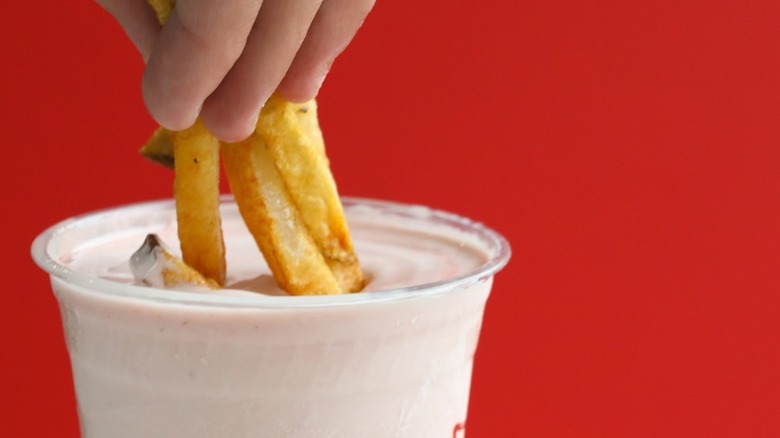 dipping french fries in milkshake