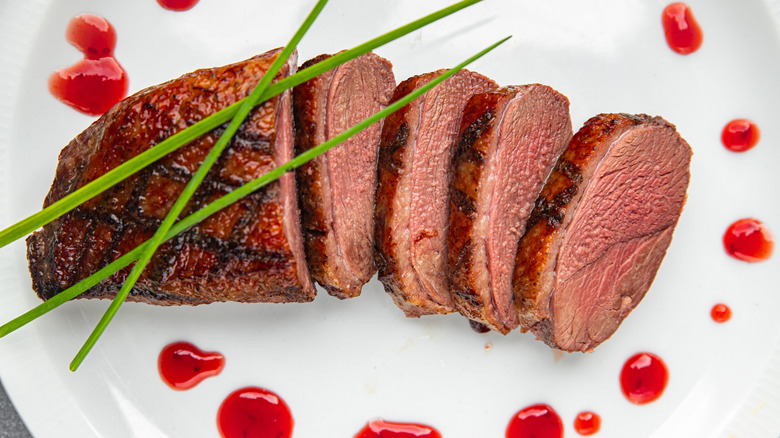 Grilled duck breast on white plate