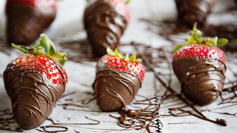 Homemade chocolate-covered strawberries on parchment paper