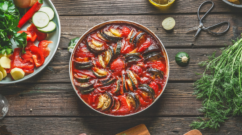 Homemade ratatouille surrounded by fresh ingredients