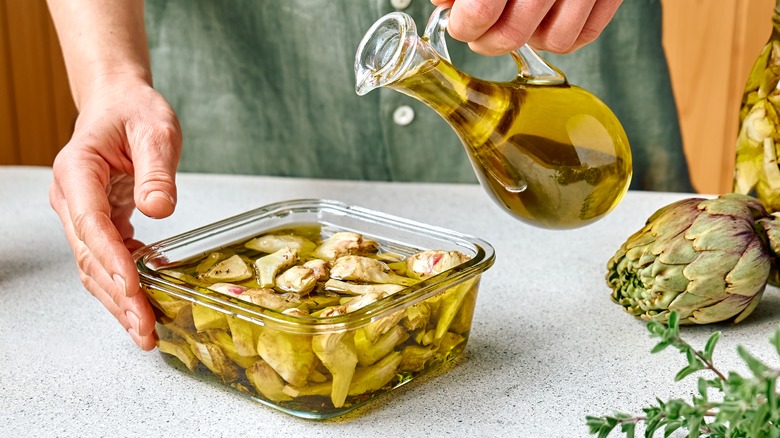 Pouring oil on artichoke hearts