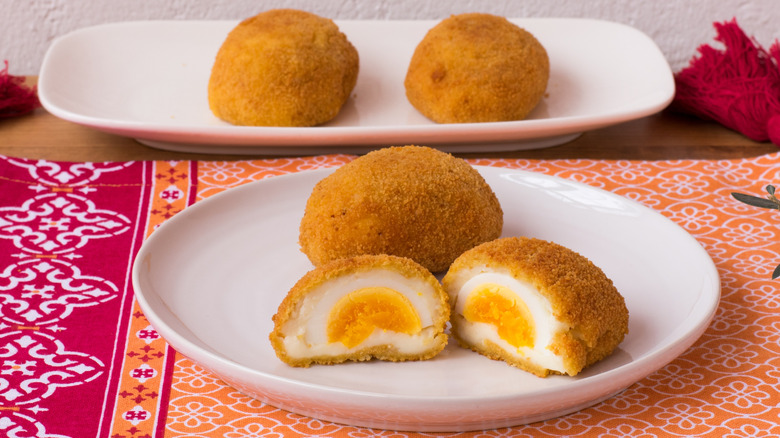 Breaded boiled eggs with bechamel on plate