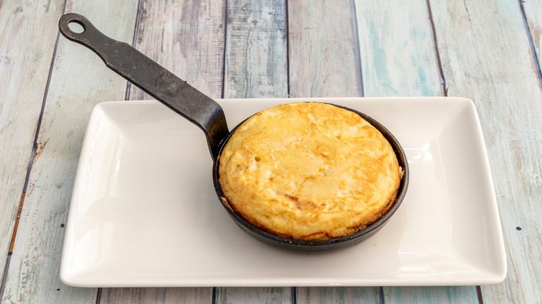 Skillet of Tortilla de Betanzos on white plate