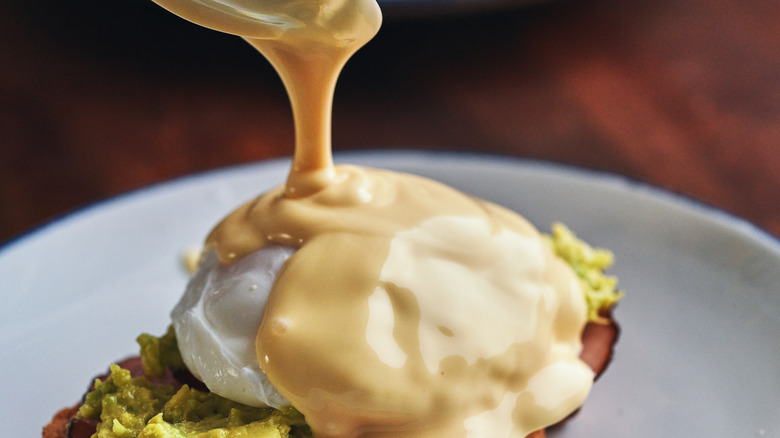 Hollandaise sauce spooned onto eggs