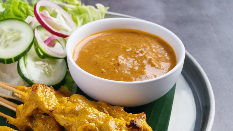 Peanut satay sauce in bowl with chicken