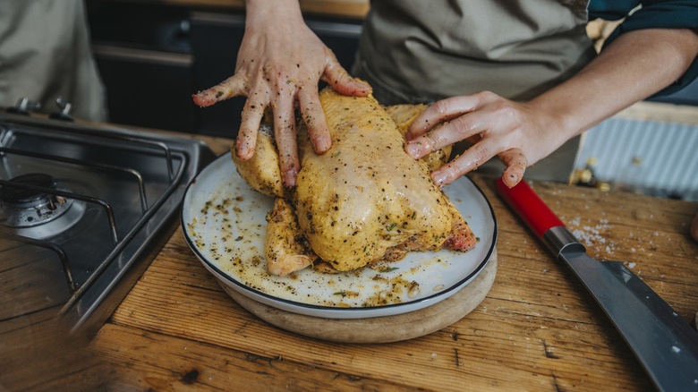 rubbing marinade into whole chicken