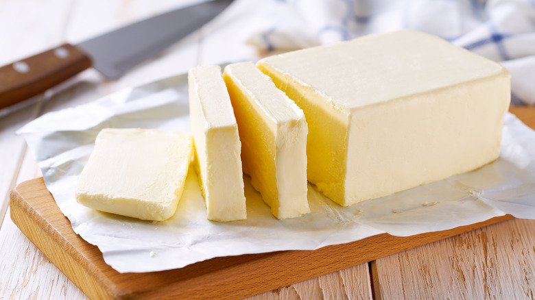 Sliced stick of butter on small board