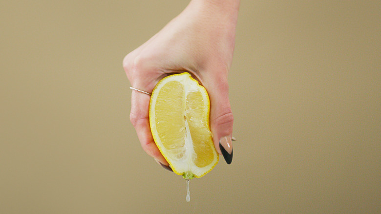 hand squeezing lemon half