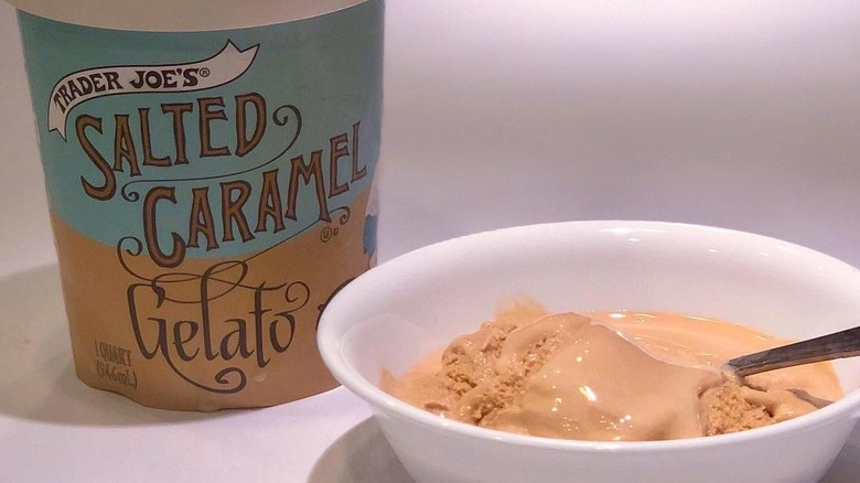 Trader Joe's carton of Salted Caramel Gelato beside white bowl of ice cream