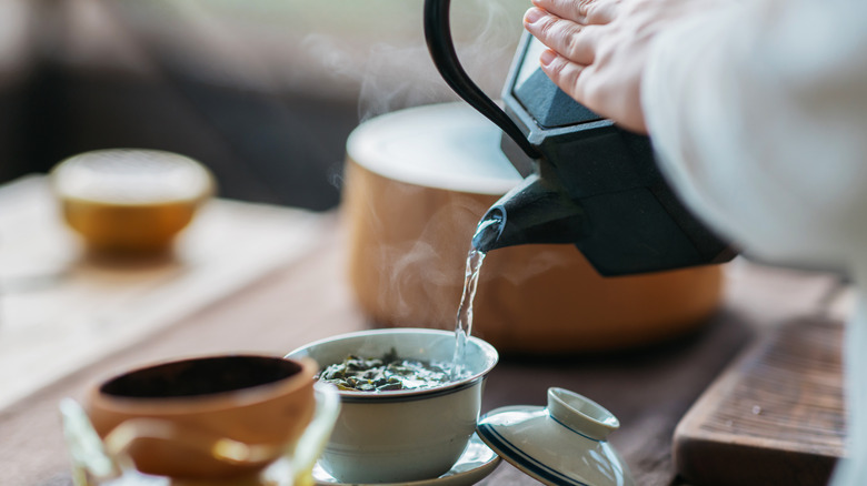 tea being poured from pot into cup