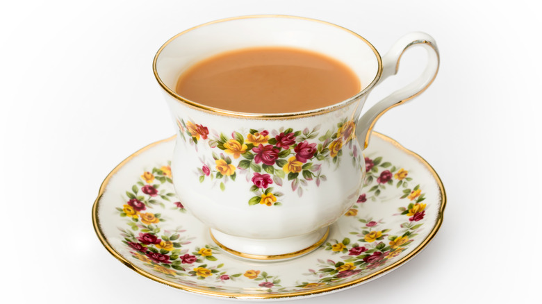 flowered teacup and saucer with tea and milk