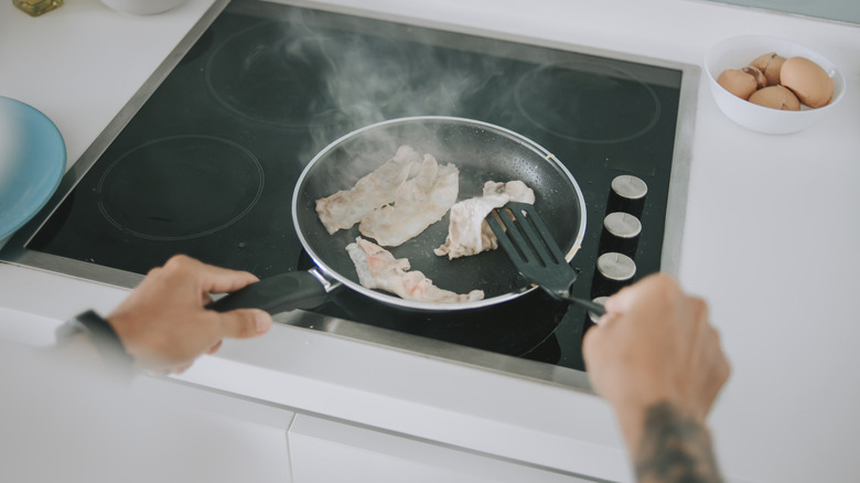 man with bacon in hot pan
