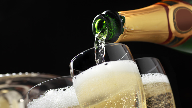 a close up of champagne being poured into a flute