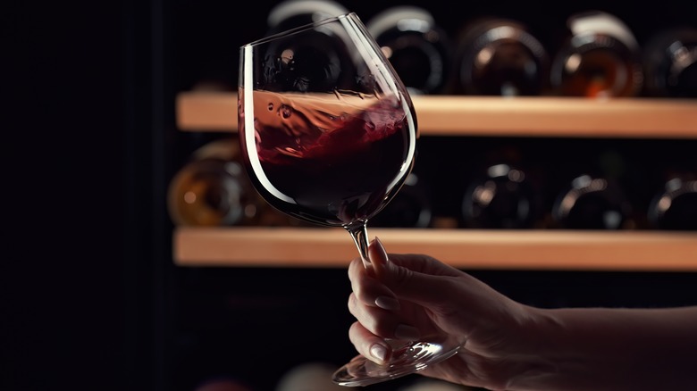 close up of a woman swirling a glass of red wine