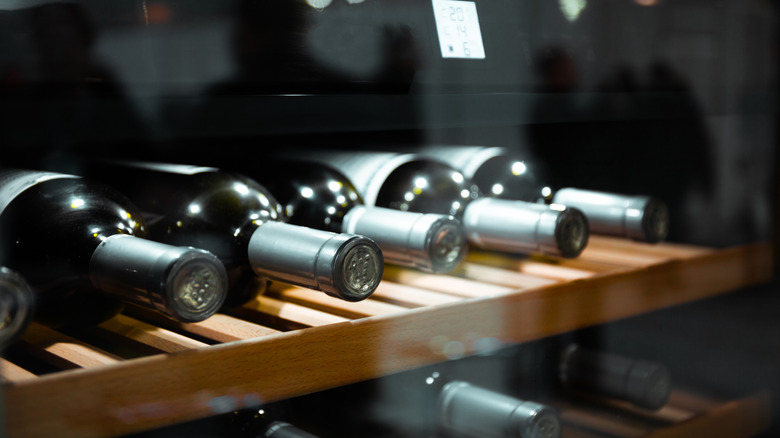 a row of red wine bottles in a wine cooler