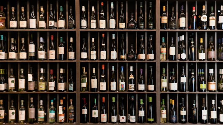 dozens of different wine bottles on a large shelving unit