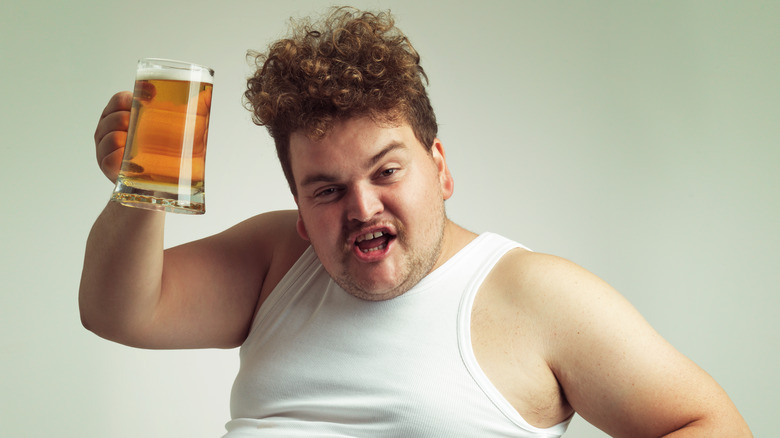 a hefty man toasting with a beer