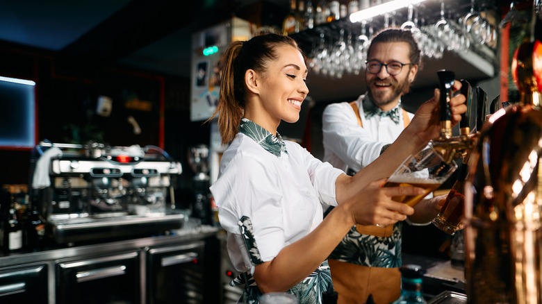 bartenders pouring from a tap