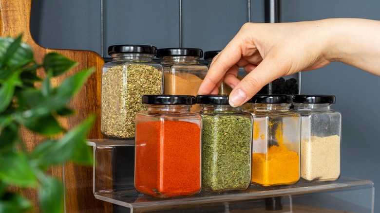 hand grabbing spice jars