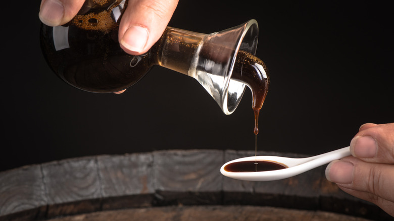 person pouring balsamic vinegar onto spoon