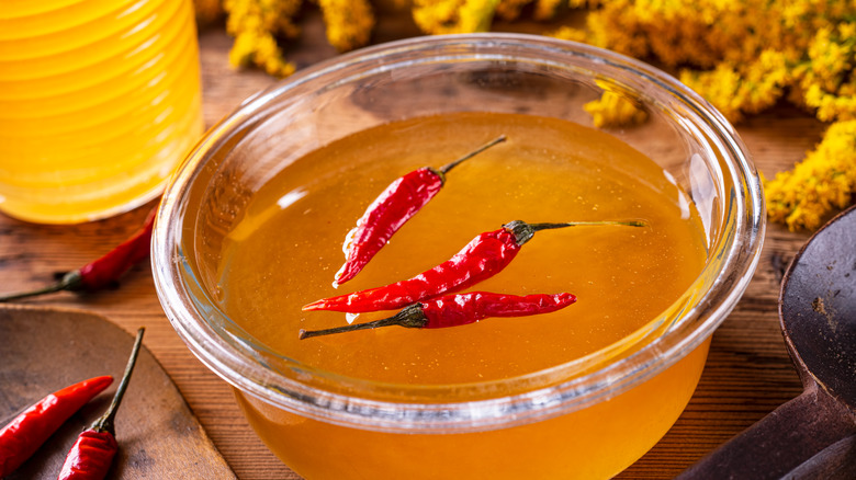 chilis floating in bowl of honey