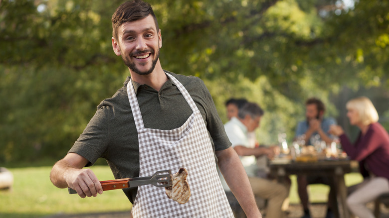 happy man wearing barbeque apron