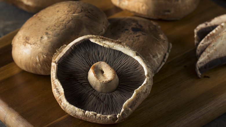 Portobello mushroom caps on board