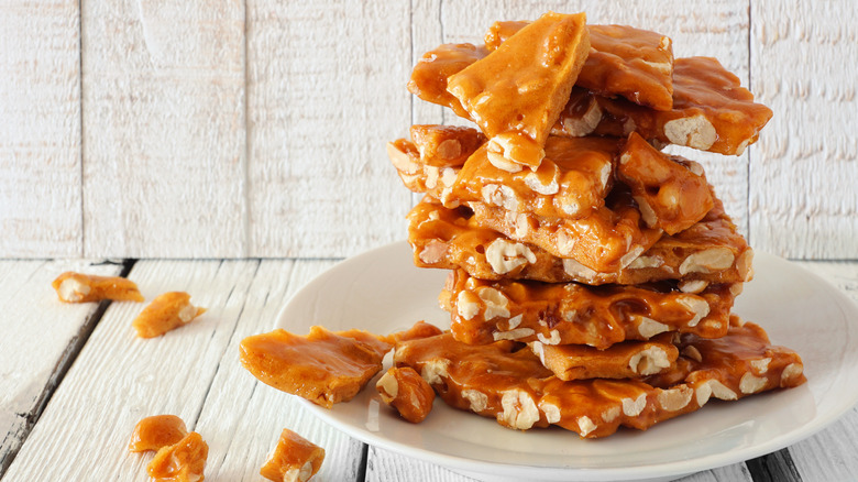 Peanut brittle stacked on a white plate