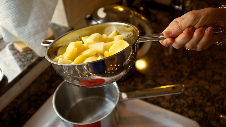person shaking potatoes in colander