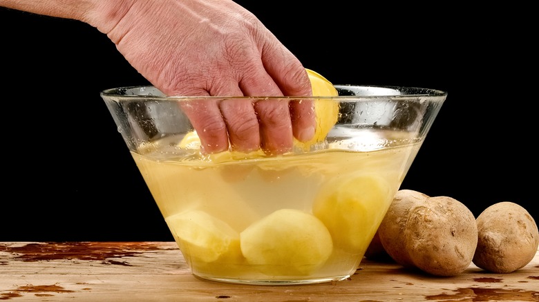 person soaking potatoes in ice water