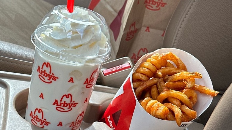 Arby's milkshake and curly fries in car console