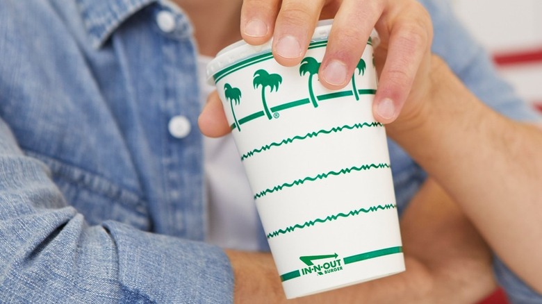 Person holding In-N-Out milkshake in a paper cup