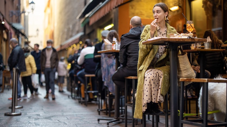 woman eating outdoor restaurant people all around