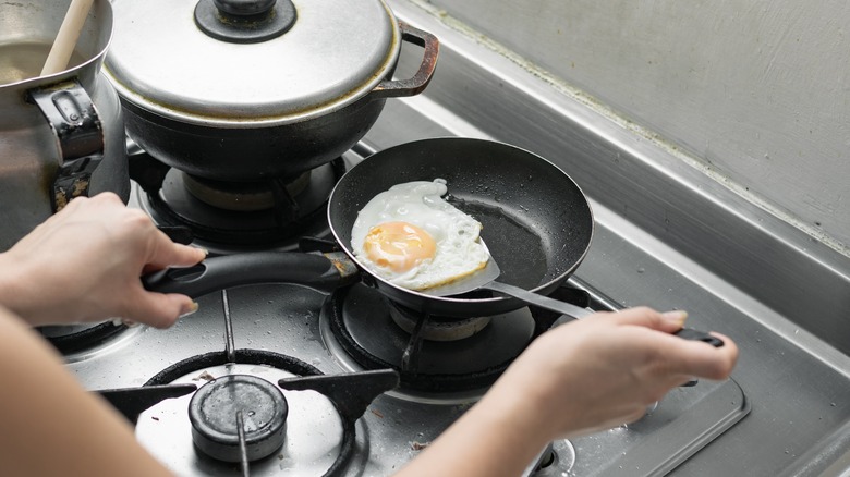 woman flipping fried egg