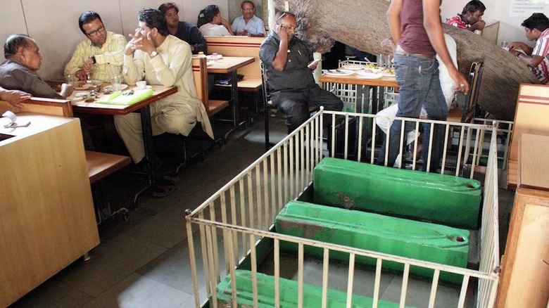 People eating next to coffins in restaurant