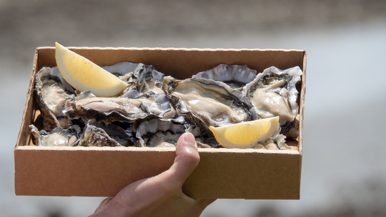 cardboard box containing bluff oysters and lemon wedges