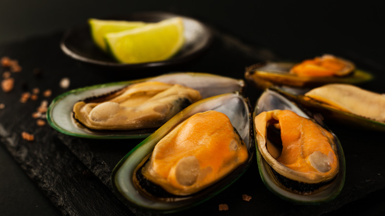 close-up of green-lipped mussels with lime wedges