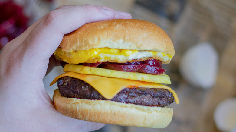 hand holding kiwi burger