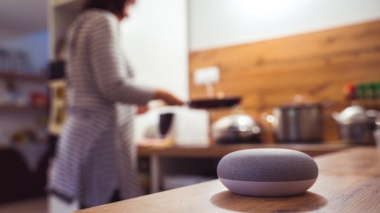 smart speaker and woman cooking in background