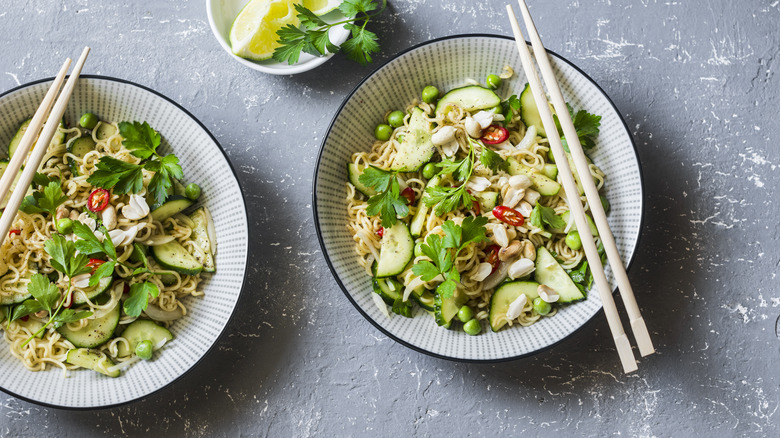 Two noodle dishes with cucumbers