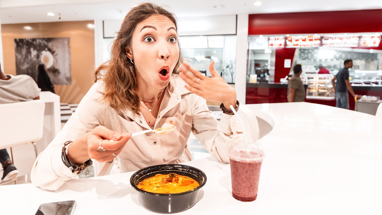 woman waving hand to cool mouth