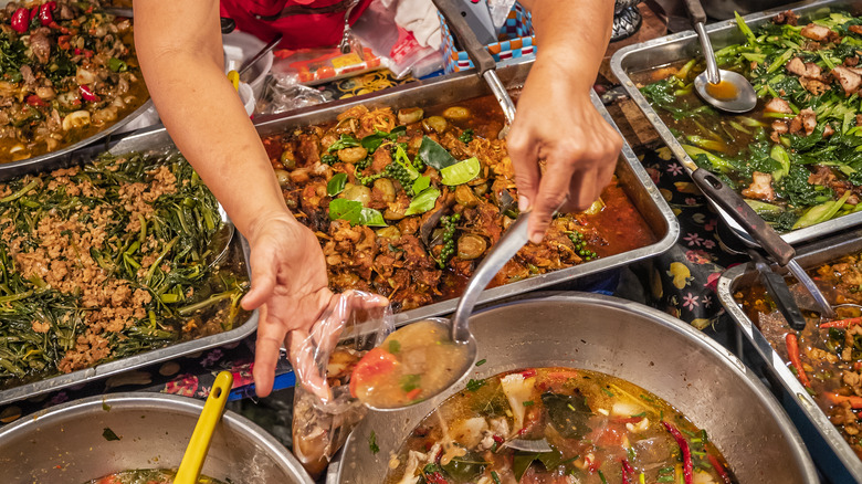 woman portioning thai food into bag