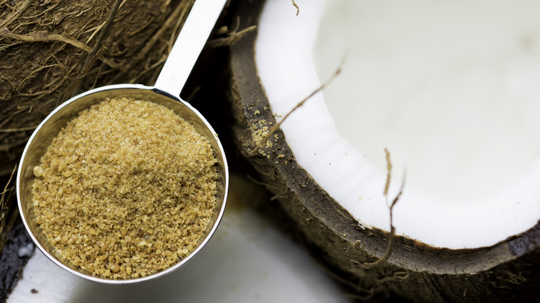 measuring spoon of coconut sugar next to coconut