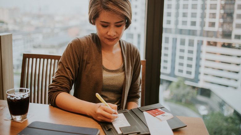 thai woman signing restaurant check